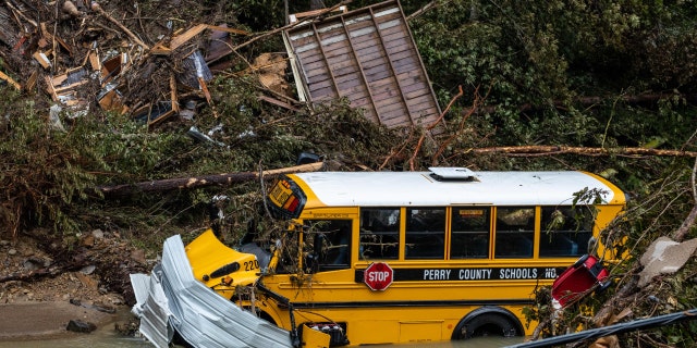 A Perry County school bus, along with other debris, sits in a creek near Jackson, Kentucky, on July 31, 2022. - Rescuers in Kentucky are taking the search effort door-to-door in worsening weather conditions as they brace for a long and grueling effort to locate victims of flooding that devastated the state's east, its governor said on July 31, 2022. 