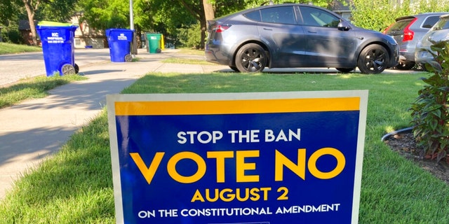 In this photo from Thursday, July 14, 2022, a sign in a yard in Merriam, Kansas, is urging voters to oppose a proposed amendment to the Kansas Constitution to allow lawmakers to further restrict or ban abortion.