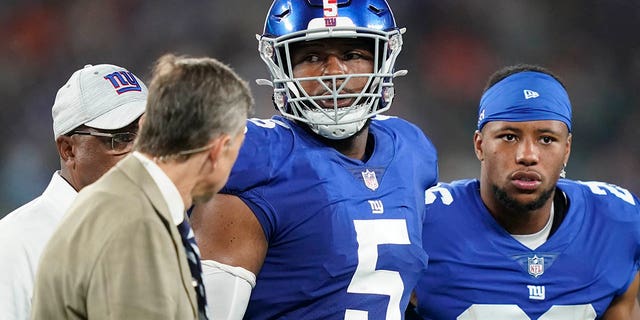 New York Giants' Saquon Barkley, #26, checks on Kayvon Thibodeaux, #5, as he is helped off the field after getting hurt during the first half of a preseason NFL football game against the Cincinnati Bengals, Sunday, Aug. 21, 2022, in East Rutherford, N.J.