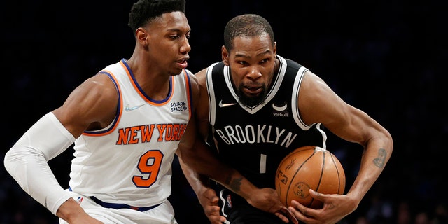 凯文杜兰特, #7 of the Brooklyn Nets, dribbles as RJ Barrett, #9 of the New York Knicks, defends during the first half at Barclays Center on March 13, 2022 在纽约市布鲁克林区.