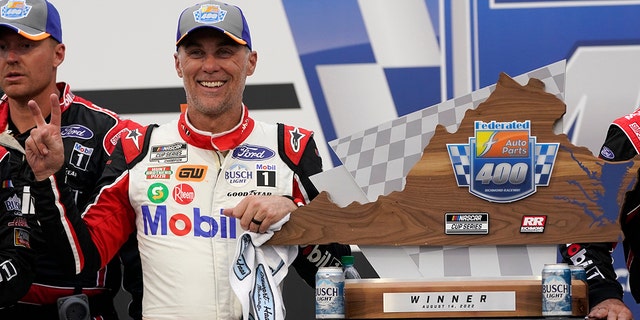 Kevin Harvick celebrates with a trophy after winning the Federated Auto Parts 400 at Richmond Raceway in Richmond, Virginia, on Aug. 14, 2022.