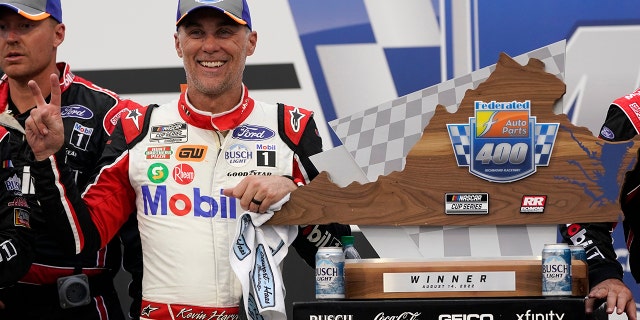 Kevin Harvick celebrates with a trophy after winning the Federated Auto Parts 400 at Richmond Raceway in Richmond, Virginia, en agosto. 14, 2022.
