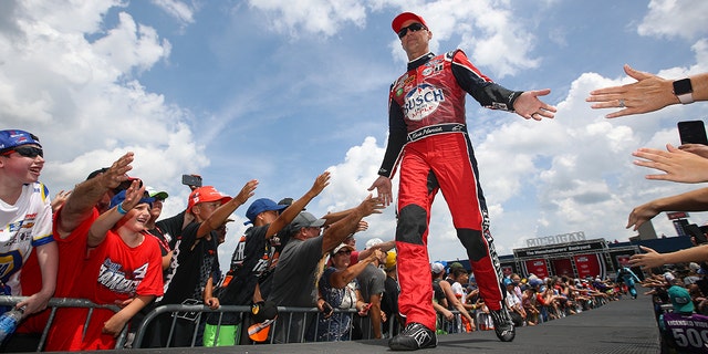 Kevin Harvick, driver of the Busch Light Apple No. 4 Ford, greets fans during driver intros prior to the NASCAR Cup Series FireKeepers Casino 400 at Michigan International Speedway, Aug. 7, 2022, in Brooklyn, Michigan.