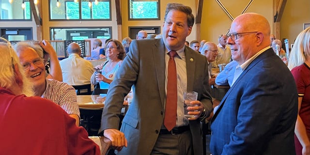 GOP Govs. Larry Hogan of Maryland (right) and Chris Sununu of New Hampshire (center) at a fundraiser for Republican state representatives, on August 30, 2022 in Manchester, N.H.