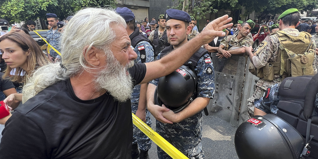 A man shouts as he protests against banks outside a bank where another armed man is holding hostages in Beirut, Lebanon, on Thursday, Aug. 11. 