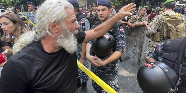 A man shouts as he protests against banks outside a bank where another armed man is holding hostages in Beirut, Lebanon, on Thursday, Aug. 11. 