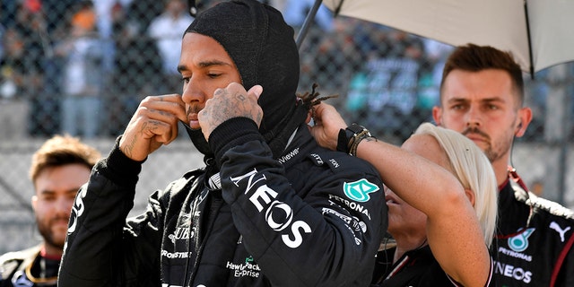 Mercedes driver Lewis Hamilton is helped by a member of his crew during the Formula One Grand Prix in Spa, Belgium, Sunday, Aug. 28, 2022.