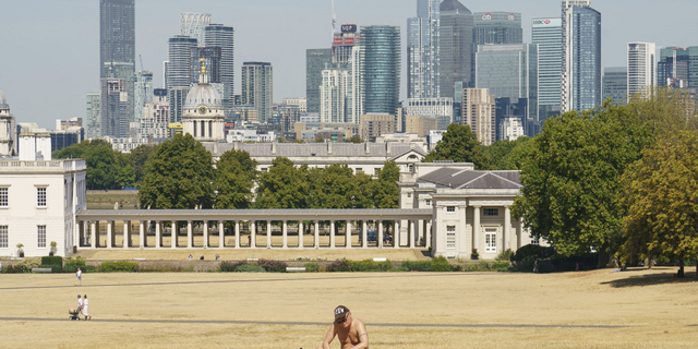 A man sunbathes in a nearly empty Greenwich Park in London on Sunday Aug. 14.