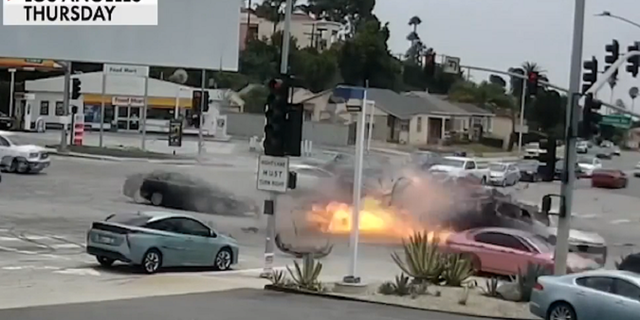 Fire is seen at an intersection in Los Angeles on Thursday, Aug. 4, right after a car collided into another at a high rate of speed.