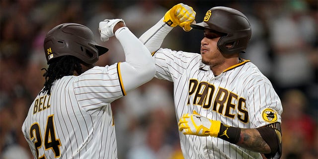 Manny Machado of the San Diego Padres celebrates with Josh Bell after hitting a home run during the fifth inning of a game against the Colorado Rockies at Petco Park on August 3, 2022 in San Diego. 