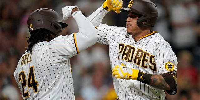 San Diego Padres' Manny Machado, right, celebrates with Josh Bell after hitting a home run against the Colorado Rockies during the fifth inning of a game at Petco Park in San Diego on August 3, 2022. 