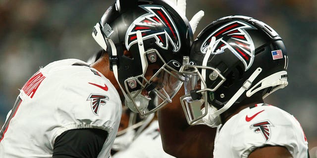 Atlanta Falcons quarterback Marcus Mariota, #1, celebrates with wide receiver Olamide Zaccheaus, right, after Zaccheaus scores a touchdown during the first half of an NFL football game against the New York Jets, Monday, Aug. 22, 2022, in East Rutherford, N.J.