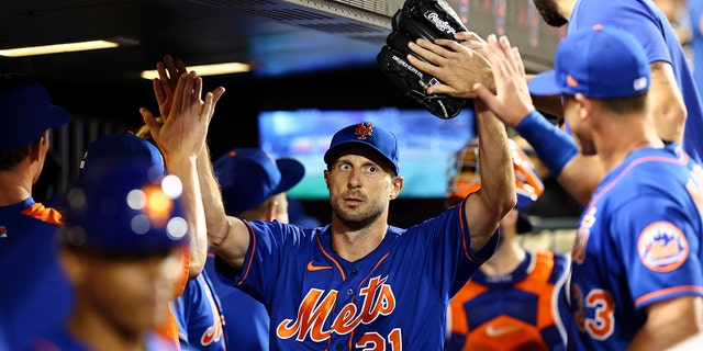 New York Mets starter Max Scherzer, 21, high-fives a teammate after the top of the seventh inning of Game 2 of a doubleheader against the Atlanta Braves in New York on Aug. 6, 2022.