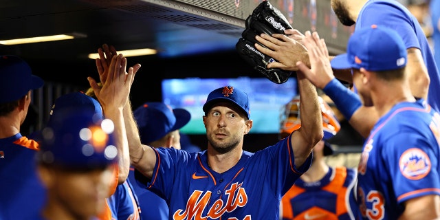 New York Mets starting pitcher Max Scherzer (21) high-fives teammates after the top of the seventh inning of the second game of a doubleheader against the Atlanta Braves, Aug. 6, 2022, in New York.