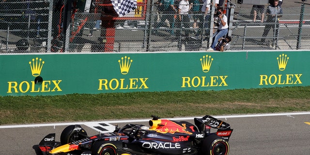 An official waves the checkered flag as Red Bull driver Max Verstappen crosses the finish line to win the Formula One Grand Prix at the Spa-Francorchamps racetrack in Spa, Belgium, Sunday, Aug. 28, 2022.