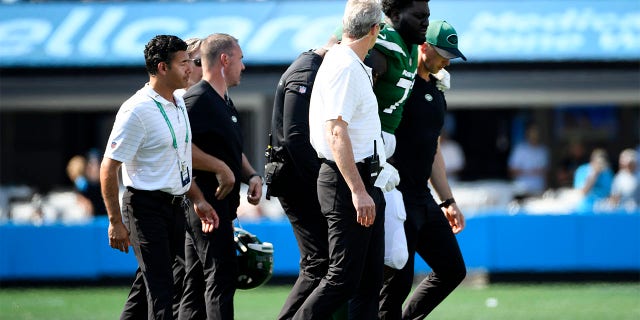 Mekhi Becton of the New York Jets is helped off the field after being injured during the Panthers game at Bank of America Stadium on Sept. 12, 2021, in Charlotte, North Carolina.