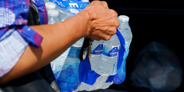A Kroger customer places a case of drinking water into her vehicle, Tuesday, Aug. 30, 2022, in Jackson, Mississippi.