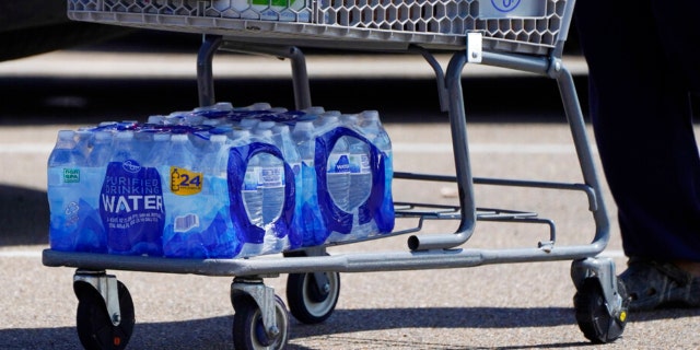 Many customers at this Kroger grocery store in north Jackson, Miss., carry out a couple of cases of drinking water, Tuesday, Aug. 30, 2022. 