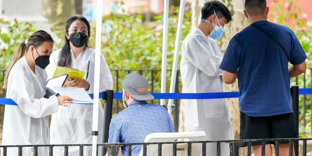 A New York City Department of Health and Mental Hygiene health care worker helps people enroll for the monkeypox vaccine at one of New York City's immunization facilities on Tuesday, July 26, 2022.