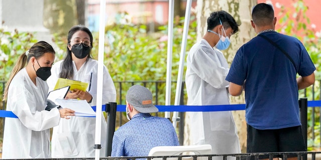 Health care workers with New York City Department of Health and Mental Hygiene help people register for the monkeypox vaccine at one of the City's vaccination sites, Tuesday, July 26, 2022, in New York.