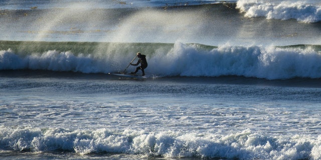 Photo taken in September 2013 shows a man surfing in the sea in Monterey where the starting point of 17-Mile Drive is located in California, United States.