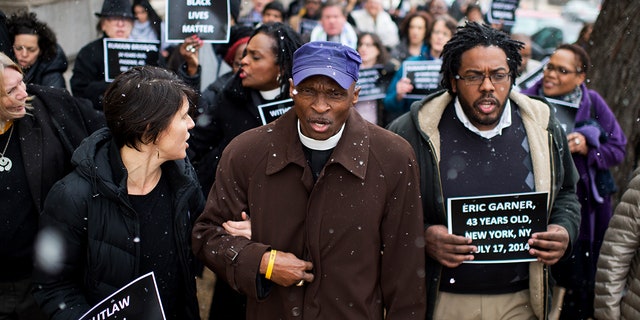 Reverend Dr.  T. Anthony Spearman, center, of North Carolina, and other protesters representing the Black Lives Matter movement, march toward the Capitol after a "in the" in Longworth's cafeteria to call on Congress to take action on racial issues.