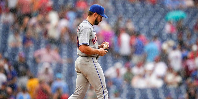 New York Mets pitcher Nate Fisher walks to the mound in a rainstorm during the sixth inning of a baseball game against the Philadelphia Phillies, Sunday, Aug. 21, 2022, in Philadelphia. 