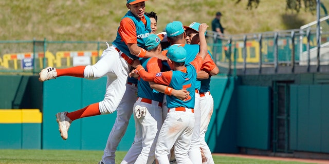 Nicaragua's Luis Garcia, left, leaps on his teammates as they celebrate the win against Panama during a baseball game at the Little League World Series tournament in South Williamsport, Pennsylvania, Tuesday, Aug. 23, 2022.