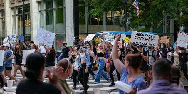 A protest against the Supreme Court's decision in the Dobbs v Jackson Women's Health case passes by a restaurant on June 24, 2022 in Raleigh, North Carolina.