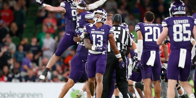Northwestern players celebrate after an interception during the second half of an NCAA college football game against Nebraska, Saturday, Aug. 27, 2022, at Aviva Stadium in Dublin, Ireland. Northwestern won 31-28.