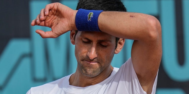 ARCHIVO - Novak Djokovic de Serbia se seca el sudor durante una sesión de práctica en el torneo de tenis Mutua Madrid Open en Madrid, España, el 30 de abril de 2022.