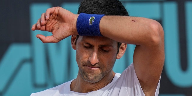 FILE - Novak Djokovic, of Serbia, wipes sweat off during a training session at the Mutua Madrid Open tennis tournament in Madrid, Spain, on April 30, 2022.