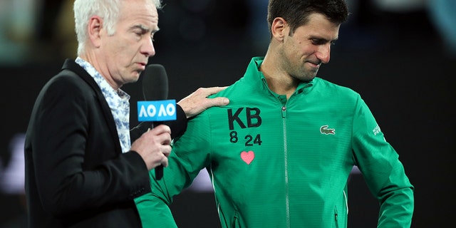 Serbia's Novak Djokovic reacts after his match against Canada's Milos Raonic as he is interviewed by former tennis player John McEnroe.