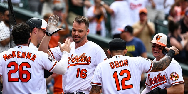 Baltimore Orioles designated hitter Trey Mancini (16) is greeted by teammates after hitting an inside-the-park home run during the eighth inning against the Tampa Bay Rays July 28, 2022, in Baltimore.