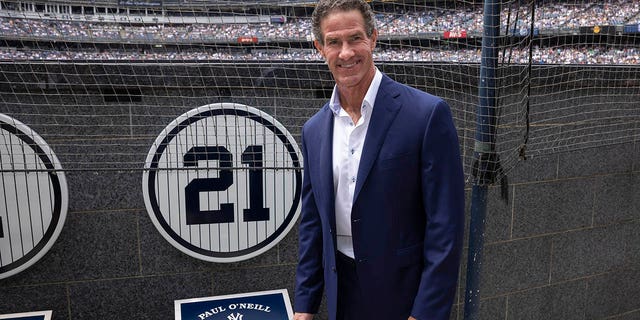 Retired New York Yankees player Paul O'Neill stands next to his number in Monument Park during a number retirement ceremony before a baseball game between the Yankees and the Toronto Blue Jays, Sunday, Aug.  21, 2022, in New York.