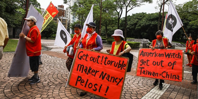 Pro-China demonstrators protest outside the Grand Hyatt hotel ahead of the arrival of US House Speaker Nancy Pelosi in Taipei, Taiwan, on Tuesday, Aug. 2, 2022.