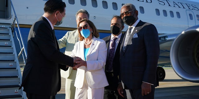 Taiwan's Foreign Minister Joseph Wu, left, speaks with U.S. House Speaker Nancy Pelosi as she prepares to leave in Taipei, Taiwan, Wednesday, Aug. 3, 2022. Pelosi left Taiwan after a visit that heightened tensions with China, saying Wednesday that she and other members of Congress in her delegation showed they will not abandon their commitment to the self-governing island.