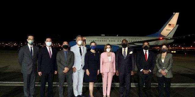 US House Speaker Nancy Pelosi poses in the center of a photo after arriving in Taipei, Taiwan, Tuesday, August 2, 2022.