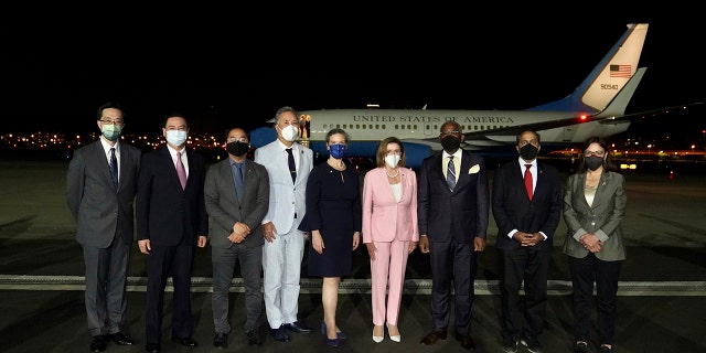 US House Speaker Nancy Pelosi poses in the center of a photo after arriving in Taipei, Taiwan, Tuesday, August 2, 2022.