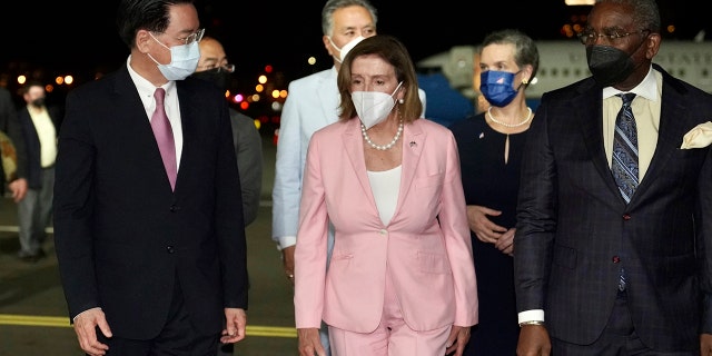Speaker of the House Nancy Pelosi walks with Taiwan Foreign Minister Joseph Wu, left, as she arrives in Taipei, Taiwan, Tuesday, August 28. 2, 2022.