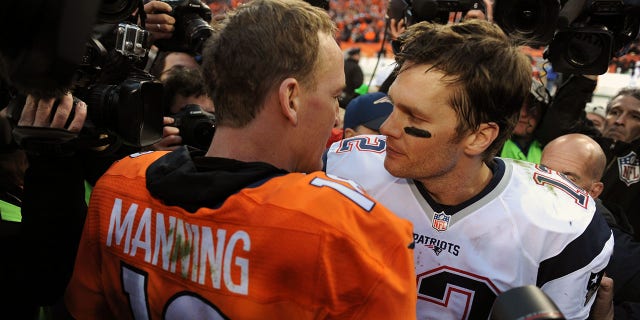 Denver Broncos QB Peyton Manning, left, is congratulated by New England Patriots Tom Brady after winning a game at Sports Authority Field at Mile High in Denver.
