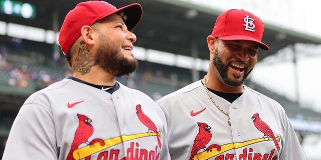 Yadier Molina #4 and Albert Pujols #5 of the St. Louis Cardinals walk off the field after a performance commemorating their last game at Wrigley Field against the Chicago Cubs on August 25, 2022 in Chicago, Illinois.