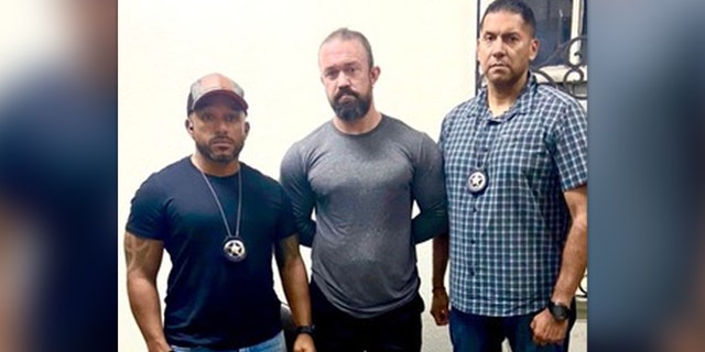 Marshals flank RJ McLeod after his arrest in Sonsonate, El Salvador, on Monday, Aug. 29, 2022.
