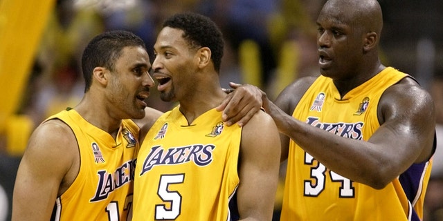 Rick Fox (L), Robert Horry (5) y Shaquille o'Neal de los Angeles Lakers celebran contra los New Jersey Nets durante el Juego 2 de las finales de la NBA el 7 de junio de 2002 en los Ángeles. 