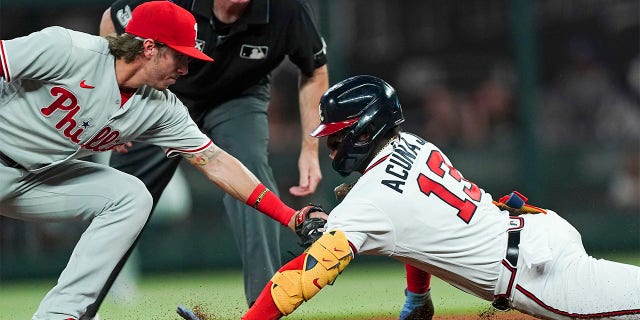 Atlanta Braves' Ronald Acuna Jr. (13) is tagged out at second base by Philadelphia Phillies second baseman Bryson Stott (5) as he tries to stretch a single in the fourth inning of a baseball game Tuesday, Aug. 2, 2022, in Atlanta.