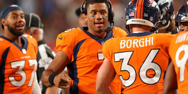 Russell Wilson (3) of the Denver Broncos celebrates a touchdown by Kendall Hinton against the Dallas Cowboys during the second quarter at Empower Field At Mile High Aug. 13, 2022, in Denver.