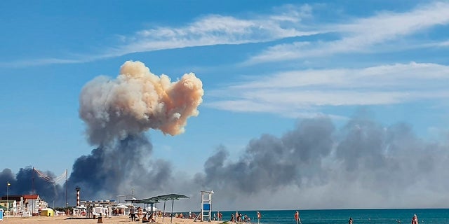Rising smoke can be seen from the beach at Saki after explosions were heard from the direction of a Russian military airbase near Novofedorivka, Crimea, on Aug. 9.