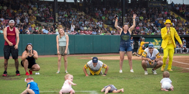 FILE - Four infants and their parents take part in what the Savannah Bananas call The Slowest Race, at the team's baseball game against the Wilmington Sharks, Saturday, June 11, 2022, in Savannah, Ga.