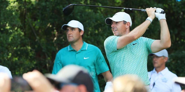 Rory McIlroy d'Irlande du Nord joue son tir du 13e tee sous le regard de Scottie Scheffler des États-Unis lors de la dernière manche du championnat TOUR au East Lake Golf Club le 28 août 2022 à Atlanta, en Géorgie.