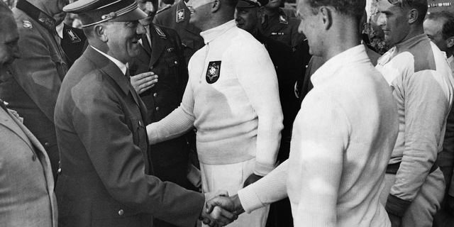 Adolf Hitler (left, foreground) congratulates shot put athletes at the 1936 Berlin Olympics, shaking hands with bronze medal winner Gerhard Stoeck of Germany. Also, from left: Nazi leader Hermann Goering, Kurt Daluege (General of Police), gold medalist Hans Woellke of Germany (center), followed by Hitler's personal adjutant Wilhelm Brueckner (half-covered) and (far right) silver medalist Sulo Baerlund of Finland, on August 2, 1936.